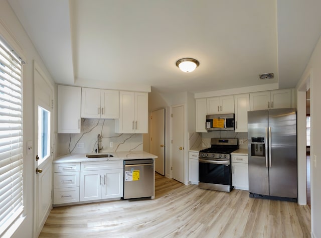 kitchen featuring white cabinetry, sink, a healthy amount of sunlight, and appliances with stainless steel finishes