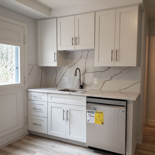 kitchen with white cabinets, dishwasher, light hardwood / wood-style floors, and sink