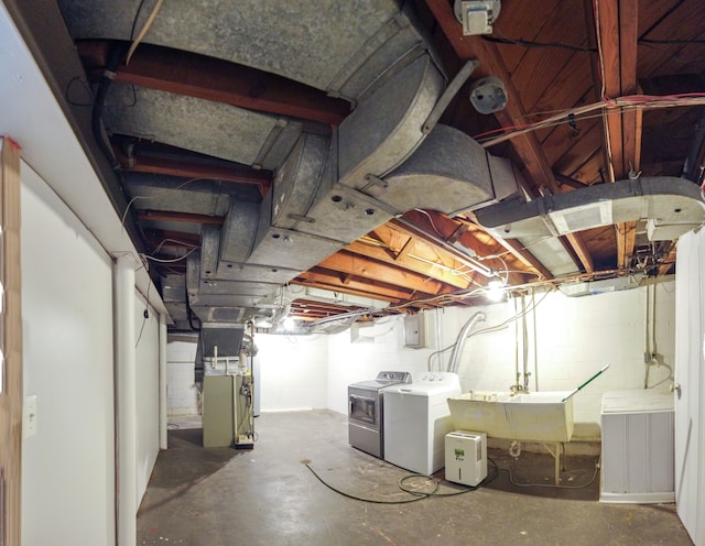 basement with heating unit, sink, and independent washer and dryer