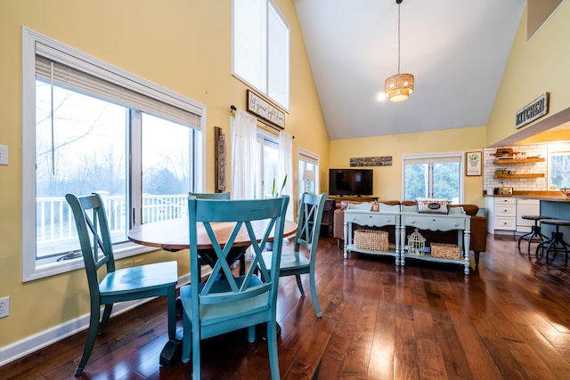 dining area featuring dark hardwood / wood-style floors and high vaulted ceiling