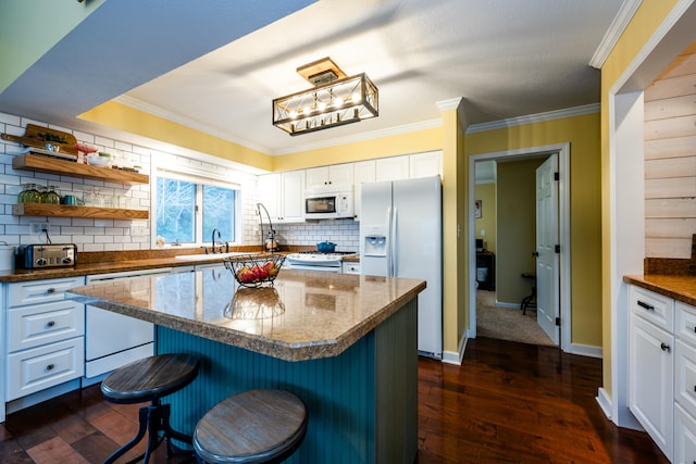 kitchen featuring a kitchen breakfast bar, a kitchen island, dark hardwood / wood-style floors, and white appliances