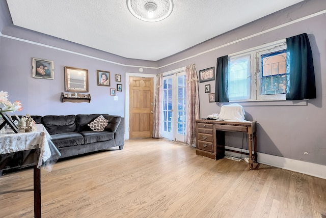 living room with a textured ceiling and light wood-type flooring