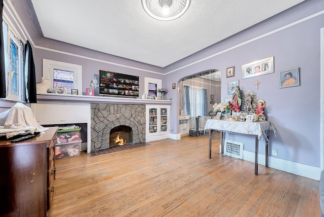 776 Woodmere St, Detroit, MI 48209 - living area featuring a textured ceiling, wood finished floors, a fireplace, and baseboards