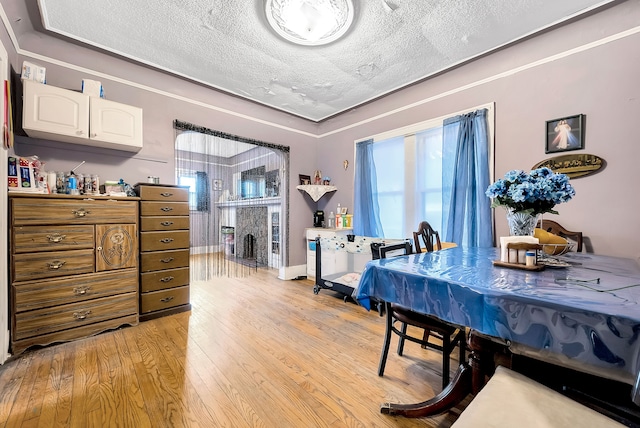 dining room featuring a textured ceiling and light hardwood / wood-style floors