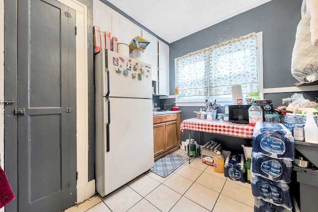 kitchen featuring white fridge and light tile patterned flooring