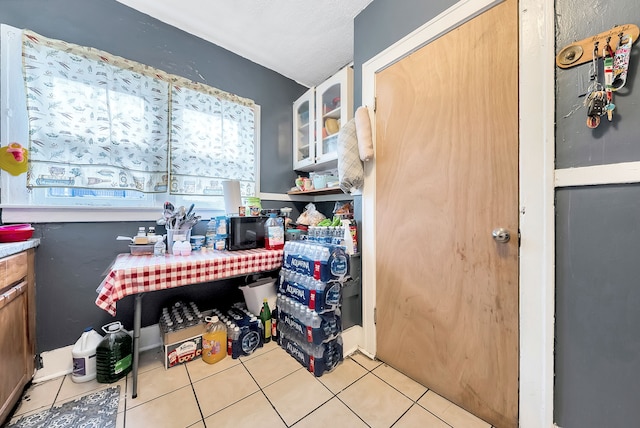 776 Woodmere St, Detroit, MI 48209 - kitchen with light tile patterned floors and glass insert cabinets