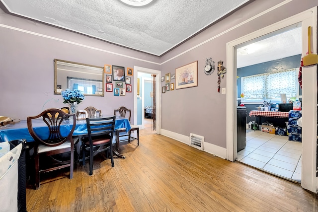 dining room featuring a textured ceiling and light hardwood / wood-style flooring