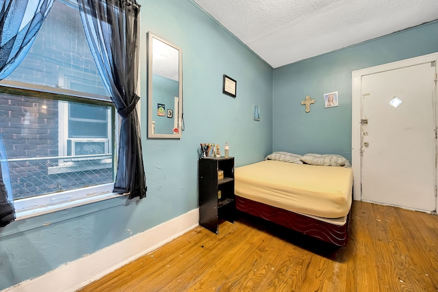 bedroom featuring wood-type flooring and a textured ceiling