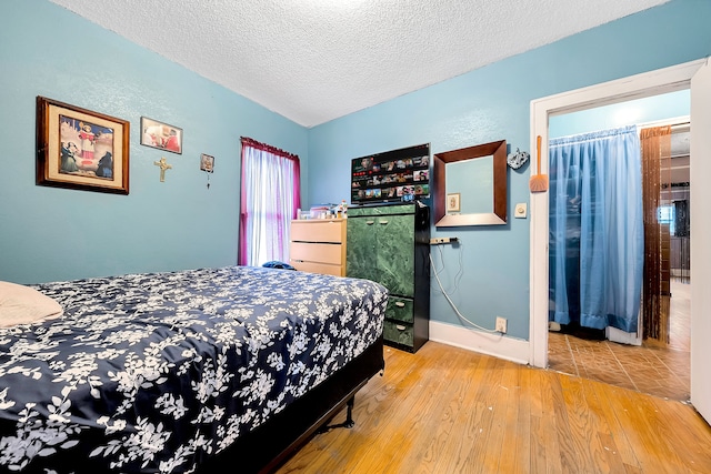 bedroom featuring hardwood / wood-style floors and a textured ceiling