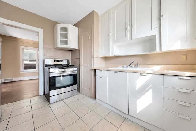 kitchen featuring stainless steel gas stove, light hardwood / wood-style floors, white cabinetry, and sink