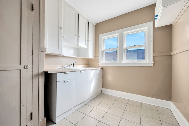 laundry area featuring sink and light tile patterned flooring