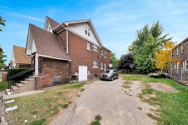 776 Woodmere St, Detroit, MI 48209 - view of home's exterior with brick siding, a shingled roof, and driveway