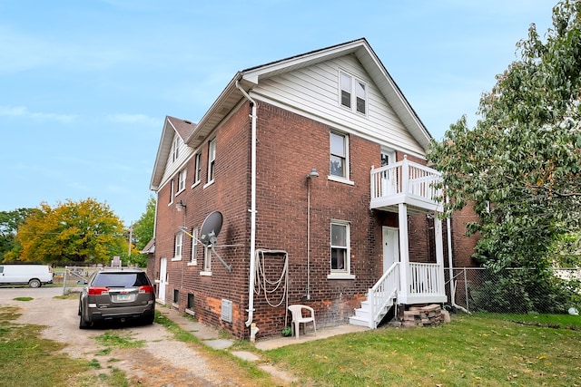 776 Woodmere St, Detroit, MI 48209 - view of side of home with brick siding, a balcony, and driveway