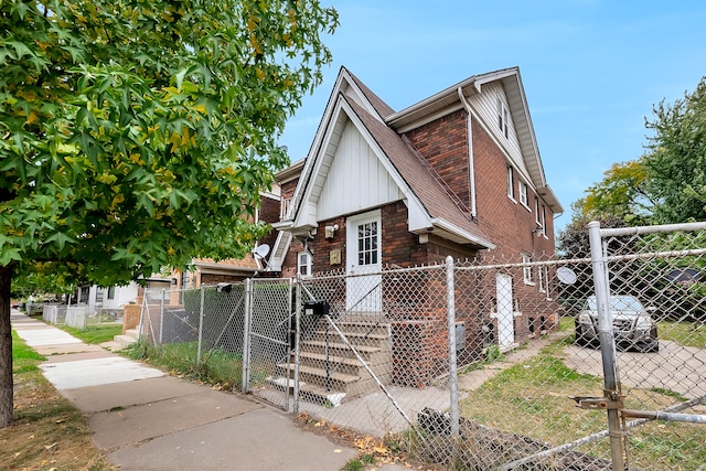 776 Woodmere St, Detroit, MI 48209 - view of front of property with a gate, a fenced front yard, board and batten siding, and brick siding