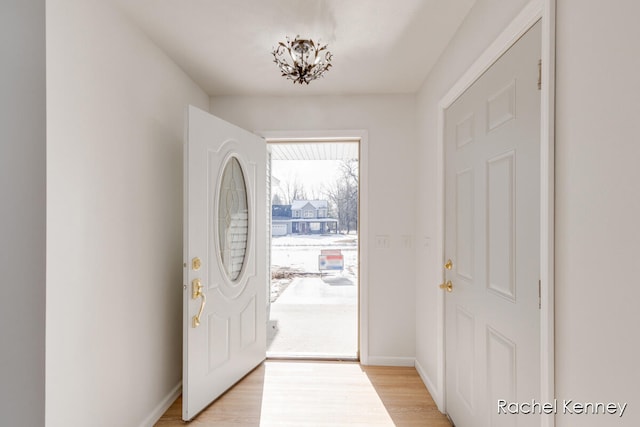 entrance foyer featuring an inviting chandelier and light hardwood / wood-style flooring