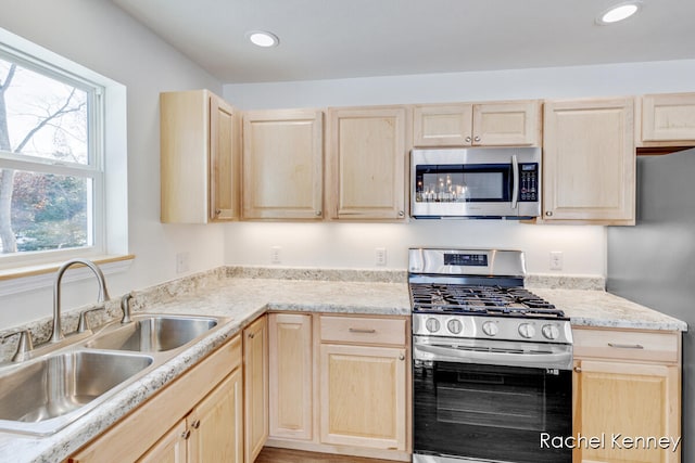 kitchen with a wealth of natural light, sink, stainless steel appliances, and light brown cabinets