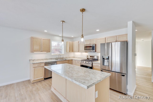 kitchen featuring appliances with stainless steel finishes, light wood-type flooring, sink, light brown cabinets, and a center island