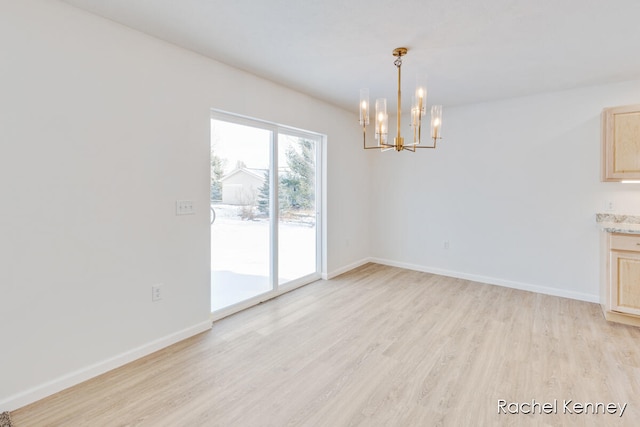 unfurnished dining area with light hardwood / wood-style floors and a notable chandelier