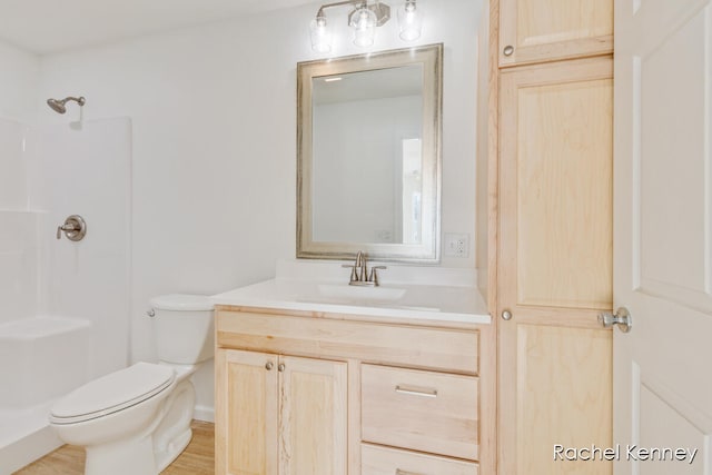 bathroom featuring walk in shower, vanity, and toilet