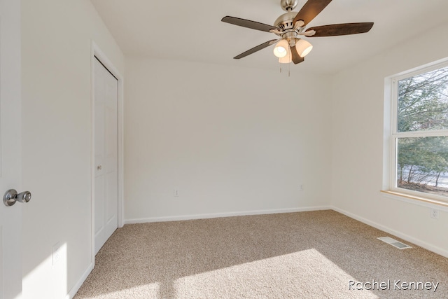 unfurnished room with carpet floors, plenty of natural light, and ceiling fan