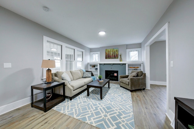 living room featuring a fireplace and light wood-type flooring