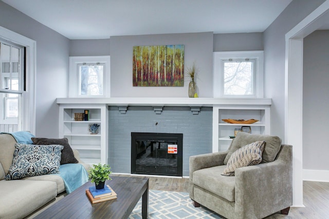 living room with hardwood / wood-style flooring, a healthy amount of sunlight, and a fireplace