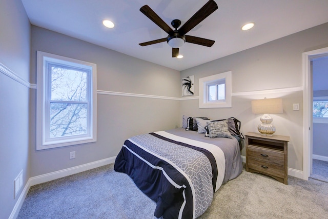 bedroom with multiple windows, light carpet, and ceiling fan