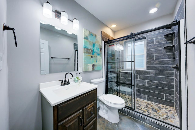 bathroom featuring tile patterned floors, vanity, toilet, and a shower with shower door