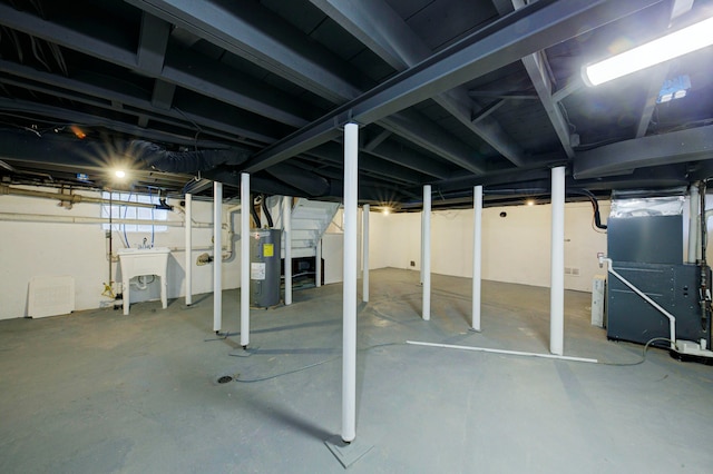 basement with sink, heating unit, and water heater