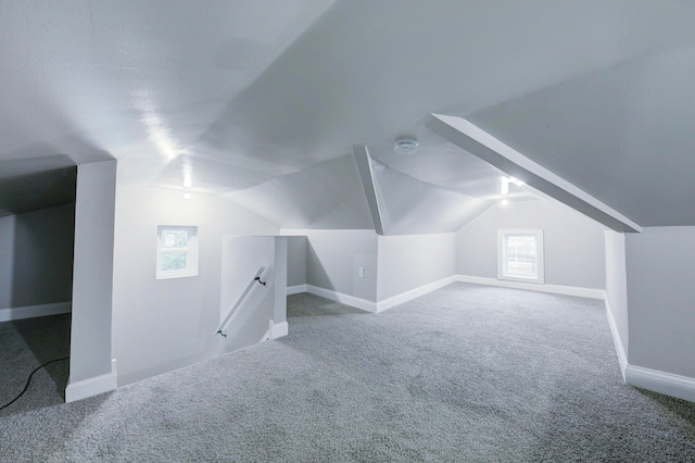 additional living space featuring lofted ceiling and carpet floors