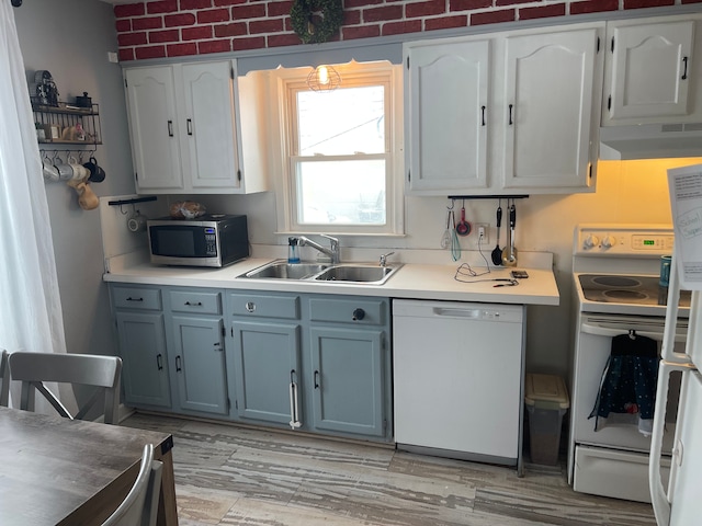 kitchen with white cabinetry, sink, brick wall, white appliances, and exhaust hood