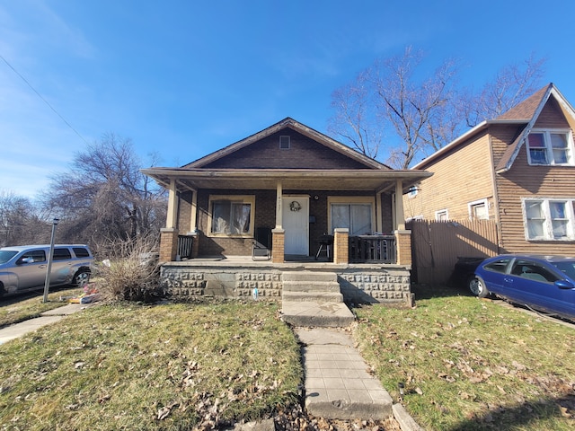 bungalow-style house featuring a front lawn and covered porch