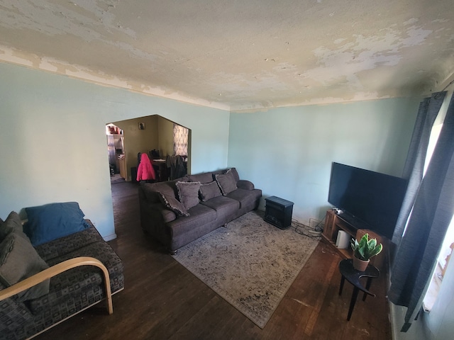 living room with a textured ceiling and dark hardwood / wood-style flooring