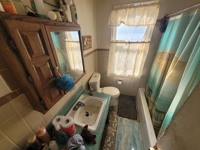 full bathroom with sink, tile patterned flooring, toilet, tile walls, and shower / tub combo