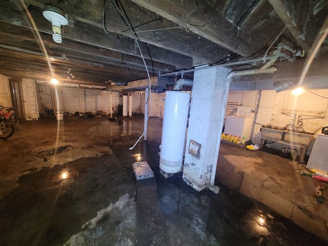 basement featuring water heater and washer / dryer