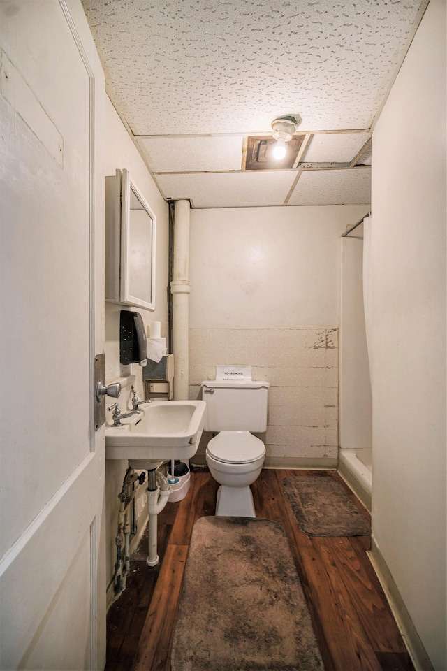 bathroom with hardwood / wood-style floors, toilet, and sink