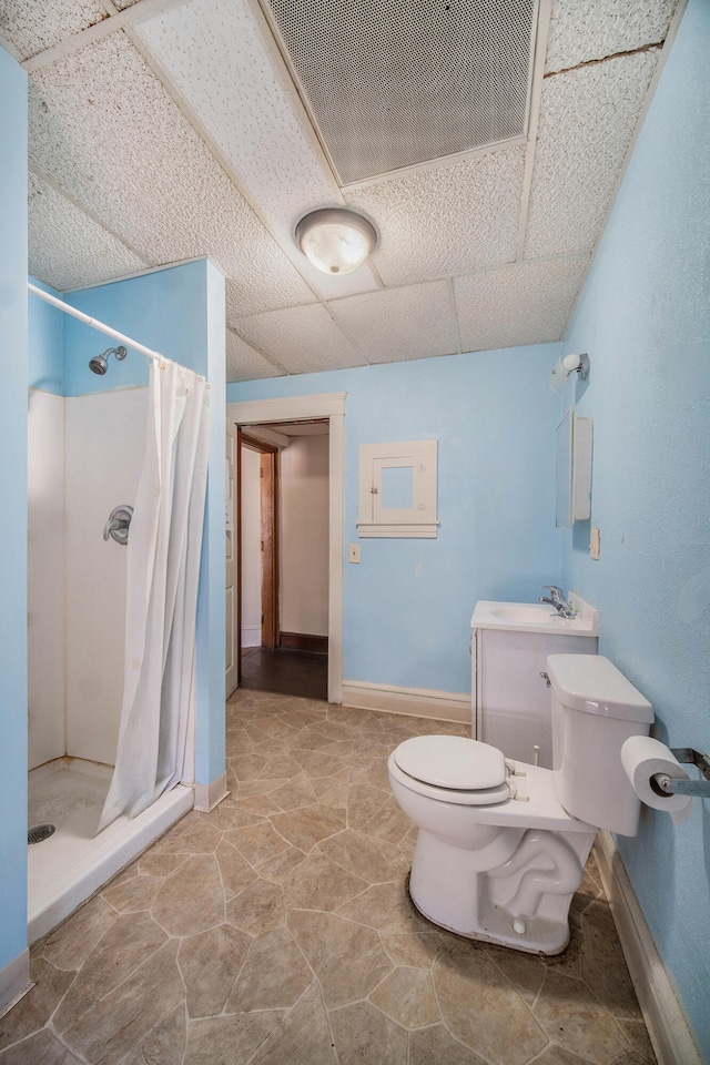 bathroom featuring a paneled ceiling, toilet, and a shower with shower curtain