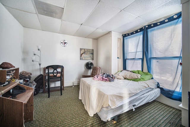 carpeted bedroom with a drop ceiling