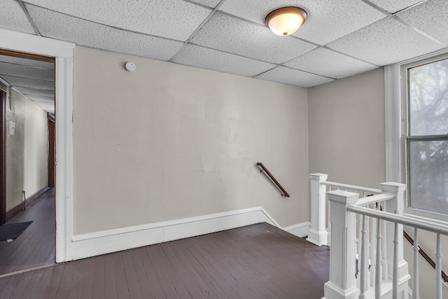 hall featuring a drop ceiling and wood-type flooring