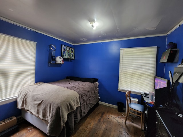 bedroom with dark wood-type flooring and ornamental molding