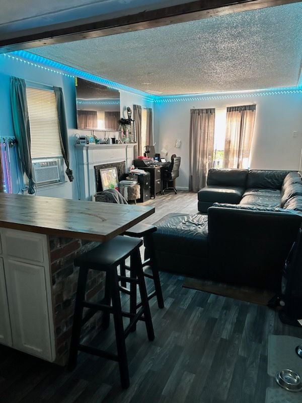 living room with a textured ceiling and dark wood-type flooring