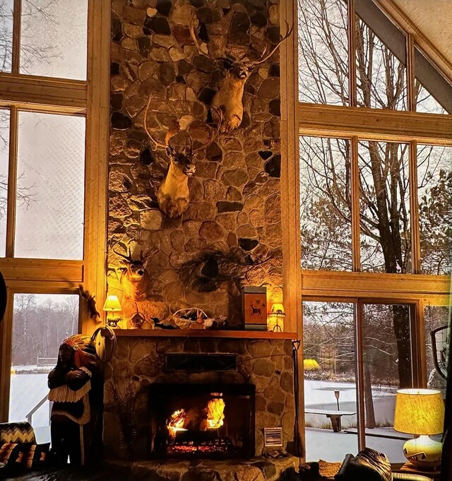 100 W Adams Rd, Farwell, MI 48622 - living area with a high ceiling, a fireplace, and healthy amount of natural light