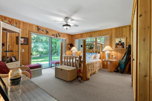 100 W Adams Rd, Farwell, MI 48622 - carpeted bedroom featuring multiple windows, wood walls, access to exterior, and a ceiling fan