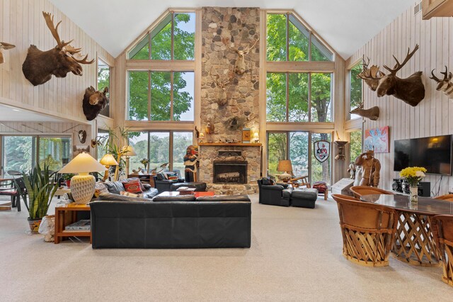 100 W Adams Rd, Farwell, MI 48622 - living area featuring high vaulted ceiling, carpet floors, a fireplace, healthy amount of natural light, and wood walls