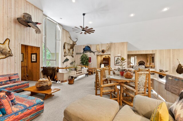 100 W Adams Rd, Farwell, MI 48622 - living area with wood walls, ceiling fan, carpet flooring, high vaulted ceiling, and recessed lighting