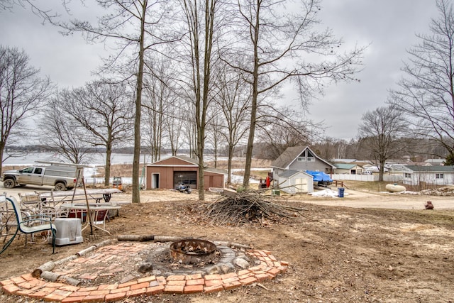 view of yard featuring an outdoor structure and an outdoor fire pit