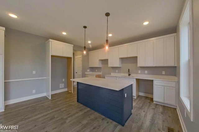 kitchen featuring white cabinets, a center island, light hardwood / wood-style floors, and sink