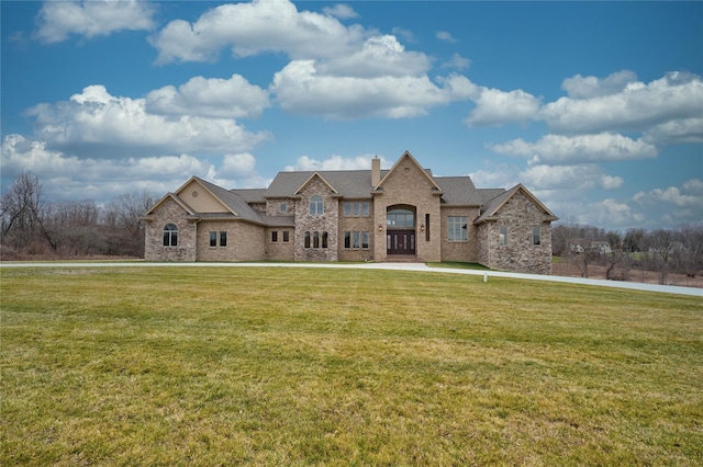 8498 Highgrove Ct, Grand Blanc, MI 48439 - french country inspired facade with a front lawn, a chimney, brick siding, and roof with shingles