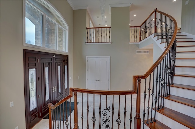 entrance foyer with crown molding and a high ceiling