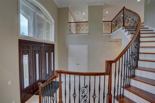 8498 Highgrove Ct, Grand Blanc, MI 48439 - foyer with a towering ceiling, stairway, baseboards, and crown molding
